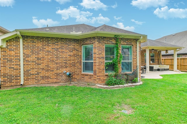view of side of home with an outdoor living space, a yard, a patio, and brick siding