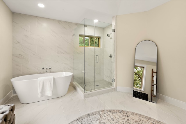 full bath featuring marble finish floor, a shower stall, plenty of natural light, and a freestanding tub