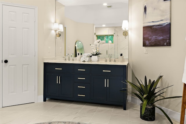 full bathroom featuring a stall shower, baseboards, double vanity, and a sink