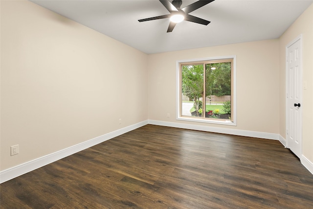 empty room featuring dark wood-type flooring, baseboards, and a ceiling fan