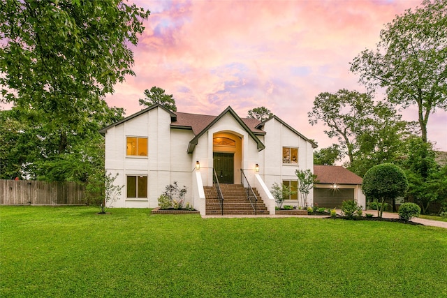 modern farmhouse style home featuring concrete driveway, roof with shingles, a front lawn, and fence