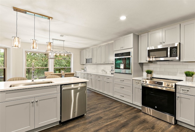 kitchen with a sink, stainless steel appliances, a wealth of natural light, and tasteful backsplash
