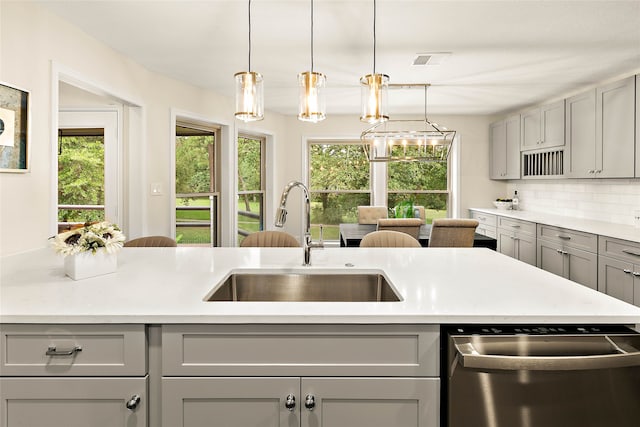 kitchen featuring light countertops, a sink, visible vents, dishwasher, and gray cabinetry