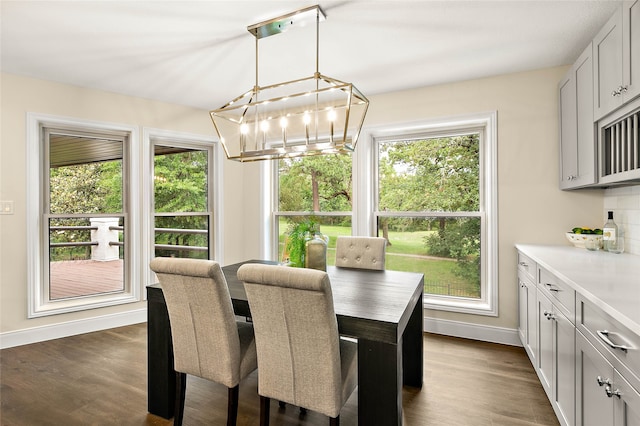 dining space featuring a notable chandelier, baseboards, plenty of natural light, and dark wood-type flooring