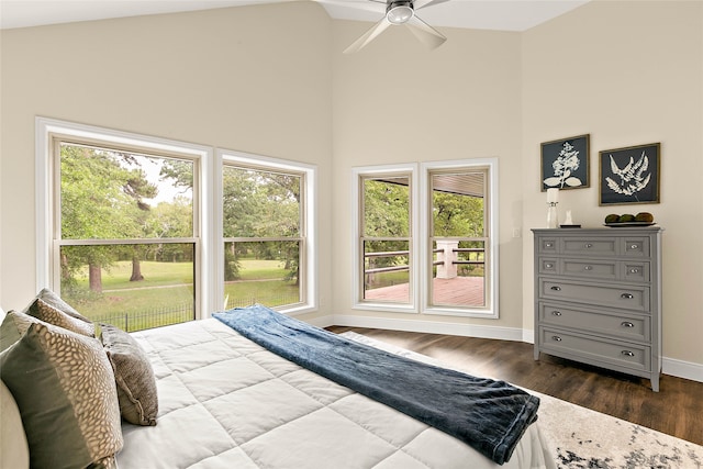 bedroom with baseboards, multiple windows, dark wood finished floors, and high vaulted ceiling