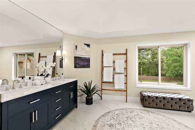 interior space with double vanity, baseboards, and a sink