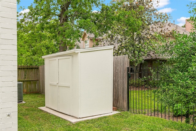 view of shed with central AC unit and fence