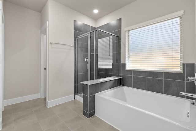 15214 Prairie Mill Dr, New Caney, TX 77357 - bathroom with a garden tub, a shower stall, tile patterned flooring, and baseboards