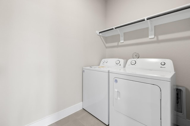 15214 Prairie Mill Dr, New Caney, TX 77357 - laundry room featuring washer and clothes dryer, baseboards, and light tile patterned floors