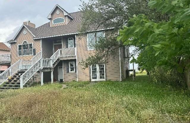 115 8th St, San Leon, TX 77539 - back of house with a chimney, stairway, and french doors
