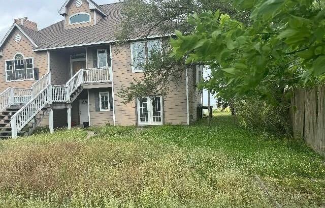 115 8th St, San Leon, TX 77539 - back of house with stairs, fence, french doors, a yard, and a chimney