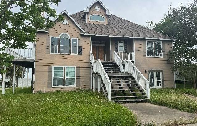 115 8th St, San Leon, TX 77539 - view of front of property with stairs, a front yard, and covered porch