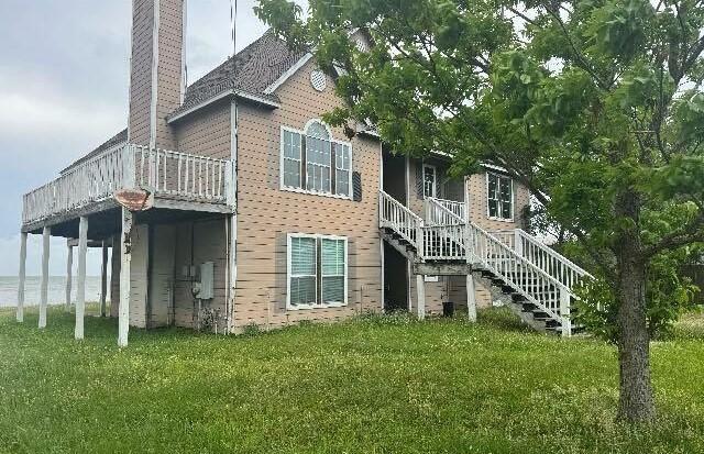 115 8th St, San Leon, TX 77539 - back of house featuring a yard, a deck, a chimney, and stairway