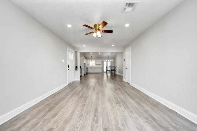 unfurnished living room featuring light wood-style floors, visible vents, a ceiling fan, and recessed lighting