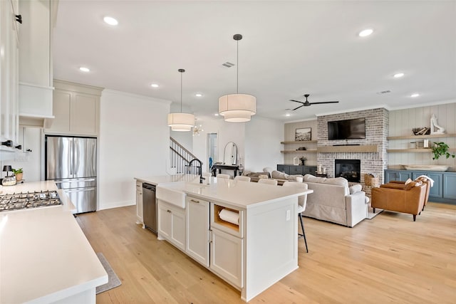 4233 Padova Cir, College Station, TX 77845 - kitchen featuring light wood-style flooring, stainless steel appliances, ceiling fan, a sink, and light countertops