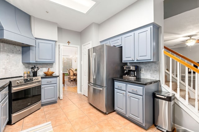 kitchen with premium range hood, stainless steel appliances, tasteful backsplash, gray cabinets, and dark countertops