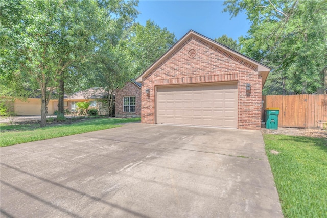 single story home featuring fence, concrete driveway, brick siding, and a front yard