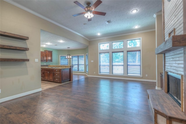 unfurnished living room with visible vents, baseboards, a fireplace, and ceiling fan
