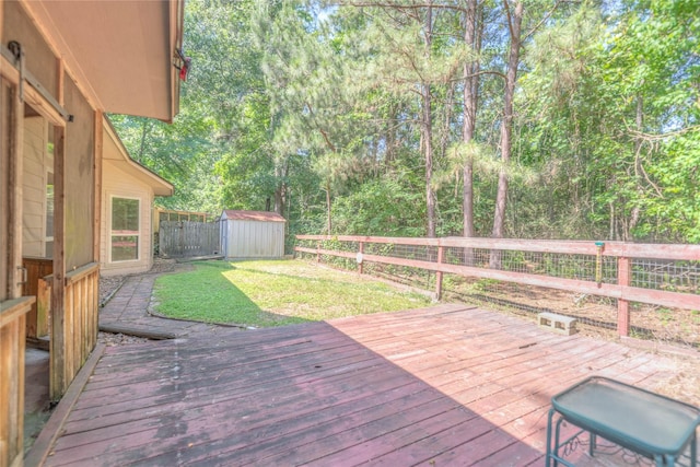 deck with a fenced backyard, a storage shed, a yard, and an outdoor structure