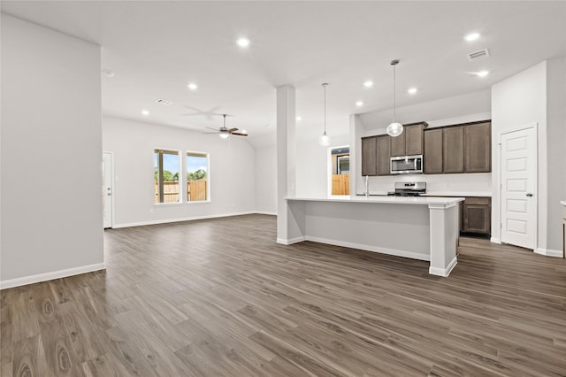 kitchen featuring stainless steel appliances, open floor plan, dark brown cabinetry, visible vents, and recessed lighting