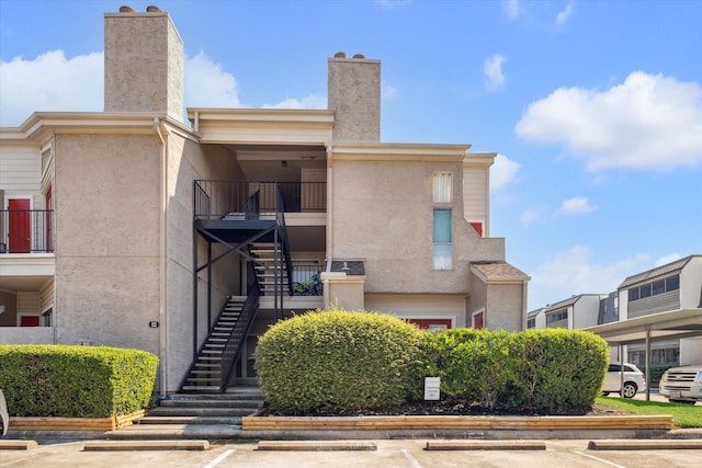 view of building exterior featuring uncovered parking and stairs