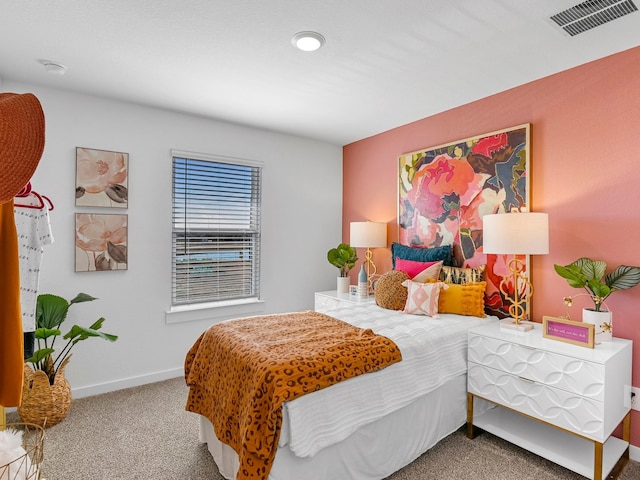 carpeted bedroom featuring baseboards and visible vents