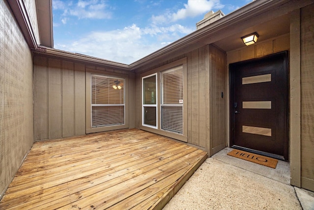 property entrance featuring a wooden deck and a chimney
