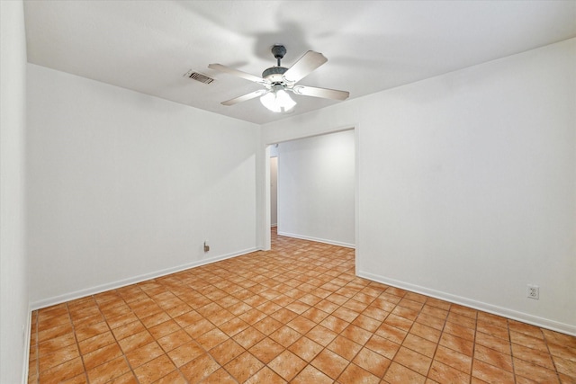 empty room featuring baseboards, a ceiling fan, and visible vents