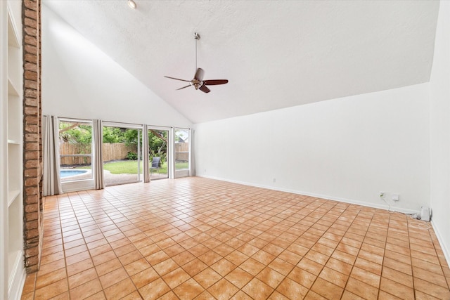 spare room featuring a textured ceiling, light tile patterned floors, baseboards, ceiling fan, and high vaulted ceiling