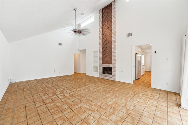 unfurnished living room featuring a brick fireplace, high vaulted ceiling, visible vents, and built in shelves