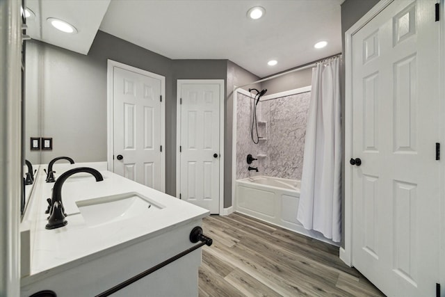 full bathroom featuring double vanity, shower / bath combination with curtain, wood finished floors, a sink, and recessed lighting