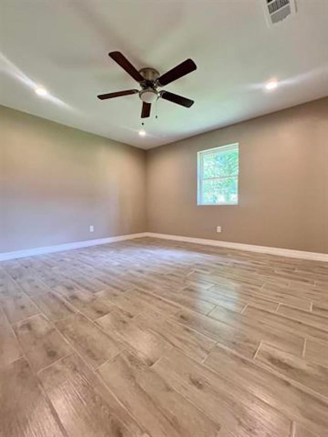 spare room featuring a ceiling fan, recessed lighting, baseboards, visible vents, and light wood-style floors