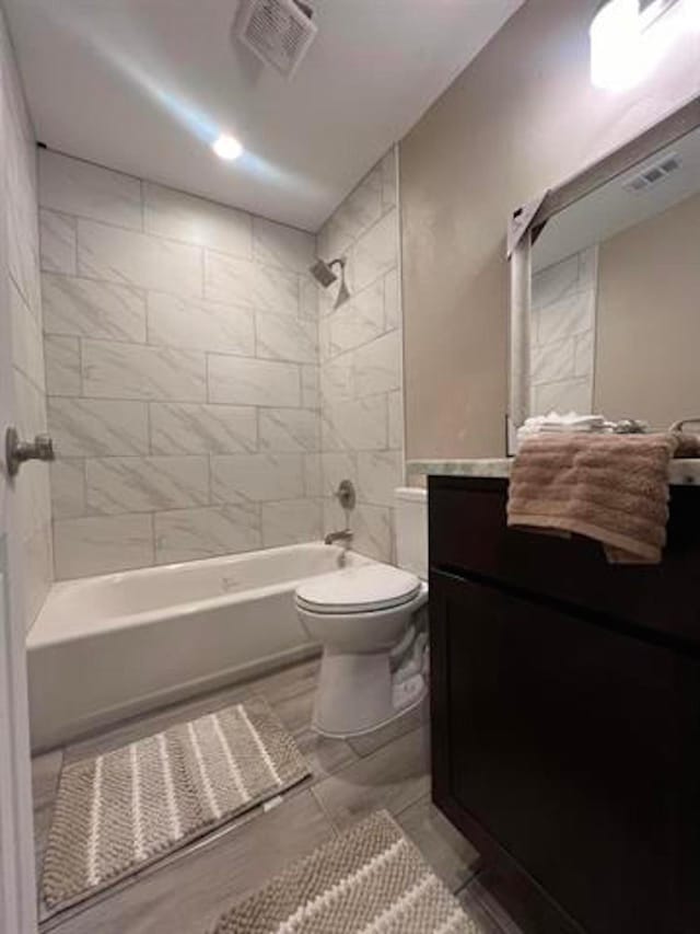 full bathroom featuring toilet, visible vents, vanity, and bathtub / shower combination