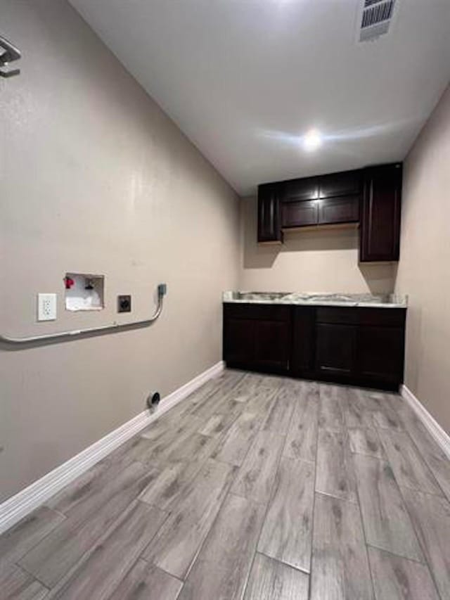 washroom featuring washer hookup, light wood-style floors, visible vents, and cabinet space
