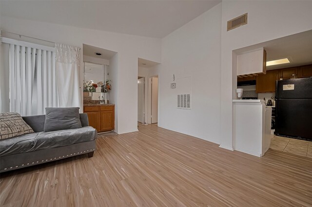 9009 Richmond Ave Unit 613, Houston, TX 77063 - living area with light wood-style flooring and high vaulted ceiling