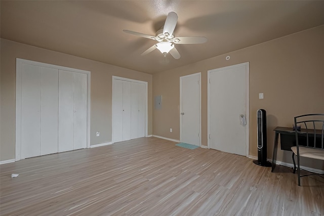 9009 Richmond Ave Unit 613, Houston, TX 77063 - unfurnished bedroom featuring multiple closets, light wood finished floors, baseboards, and ceiling fan