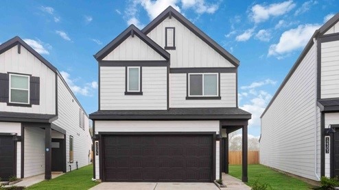 3119 Crown Gate Dr, Houston, TX 77047 - view of front facade with driveway, a garage, a front lawn, and board and batten siding