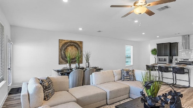 3119 Crown Gate Dr, Houston, TX 77047 - living room featuring light wood finished floors, visible vents, baseboards, ceiling fan, and recessed lighting