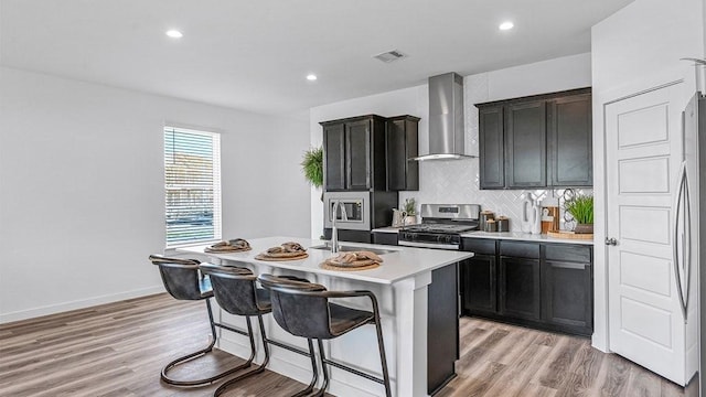 3119 Crown Gate Dr, Houston, TX 77047 - kitchen featuring light countertops, a sink, stainless steel appliances, a kitchen island with sink, and wall chimney range hood