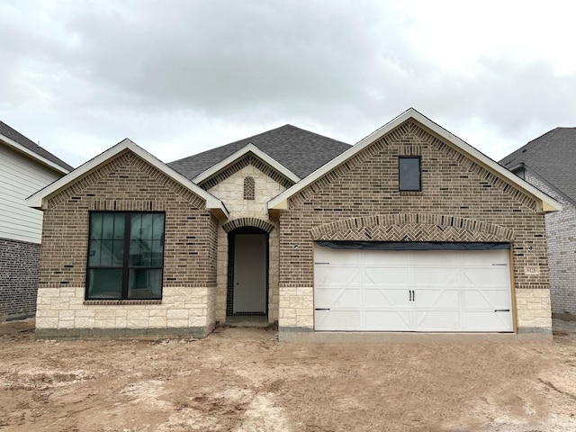 6126 Severson Lk, Katy, TX 77493 - french country home featuring stone siding, a garage, a shingled roof, brick siding, and driveway