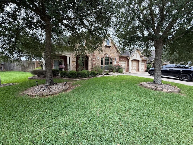 4315 Sanctuary Hills Ct, Spring, TX 77388 - view of front facade featuring an attached garage, a front lawn, stone siding, and driveway
