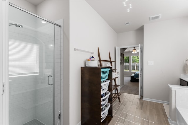 1226 Tilia Creek Ln, Montgomery, TX 77316 - ensuite bathroom featuring a stall shower, a ceiling fan, wood tiled floors, and baseboards