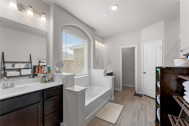 1226 Tilia Creek Ln, Montgomery, TX 77316 - full bathroom with a garden tub, two vanities, wood finished floors, and baseboards