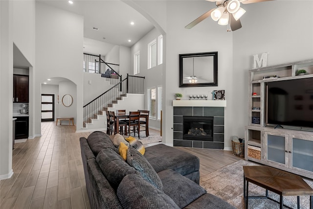1226 Tilia Creek Ln, Montgomery, TX 77316 - living room with arched walkways, a ceiling fan, wood finished floors, stairs, and baseboards