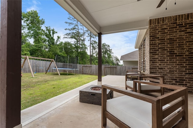 1226 Tilia Creek Ln, Montgomery, TX 77316 - view of patio with a fire pit, a trampoline, ceiling fan, outdoor dining area, and a playground
