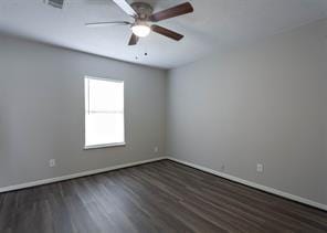 empty room featuring visible vents, wood finished floors, baseboards, and ceiling fan