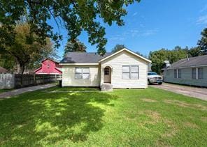 bungalow with a front lawn, fence, and entry steps