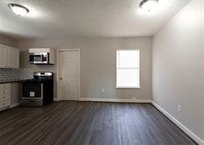 kitchen with stainless steel appliances, white cabinetry, baseboards, backsplash, and dark wood-style floors