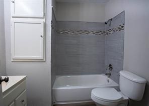 bathroom with toilet, vanity, and shower / bathtub combination