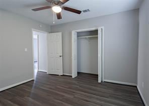 unfurnished bedroom with ceiling fan, baseboards, a closet, and wood finished floors